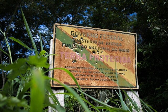 Placa furada de balas próxima à linha 623: aviso deixado por ladrões de madeira na porta da casa dos Uru-eu-au-au [Foto Kanindé] - Gente de Opinião