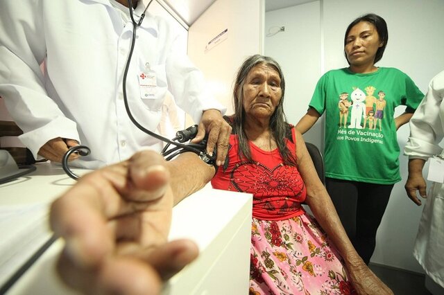 Oruao Caraxu Oro Nao, 79 anos, chega ao barco da saúde com dor cervical. À direita, durante o atendimento médico, a enfermeira Alcilene Oro Waran, 30, nascida na Aldeia Tanajura [Foto Alex Leite]   - Gente de Opinião